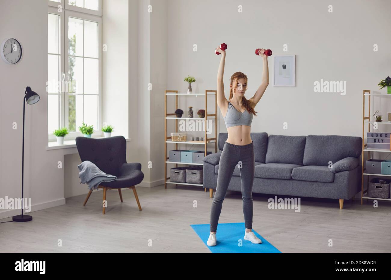 Girl doing sports workout with dumbbels at home Stock Photo