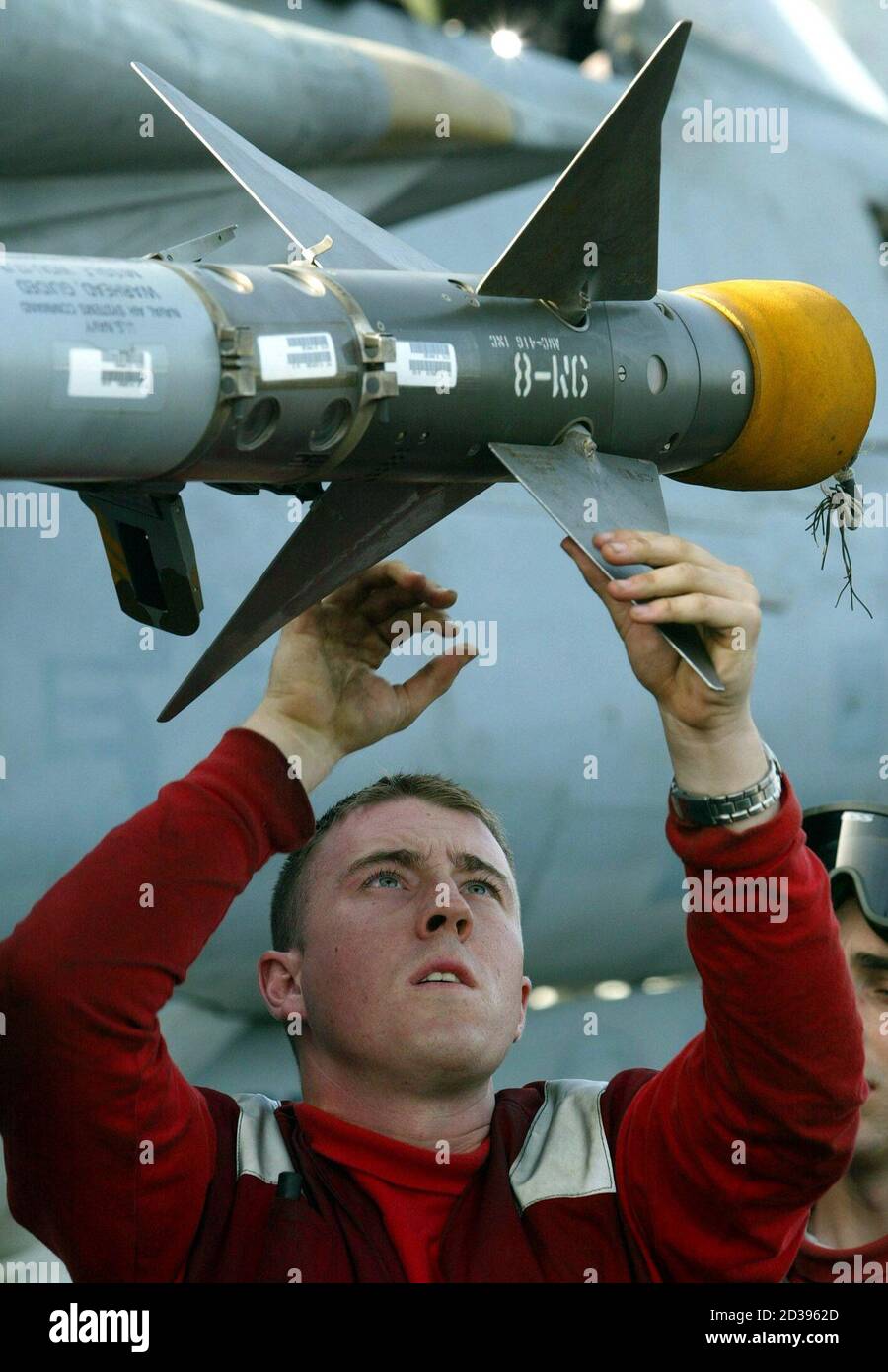 Airman Ordnance crew member Scott Inke, from Mississippi, inspects the fins on an AIM-9 Sidewinder missile on a F/14D Tomcat on board the USS Abraham Lincoln aircraft carrier in the Gulf, February 23, 2003. The USS Abraham Lincoln is part of an eight-ship battle group operating in the Gulf in support of Operation Southern Watch, as U.S. Secretary of State Colin Powell, on a visit to Japan, dropped heavy hints about Washington's timetable for war in Iraq, saying the U.N. ought to decide what to do soon after a weapons inspectors' report expected on March 7. REUTERS/John Schults  JES/JV Stock Photo
