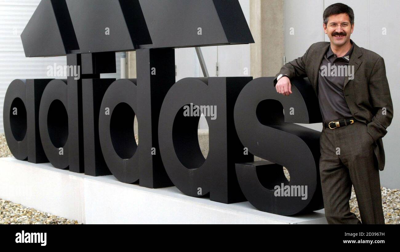 CEO of the world's second-biggest sporting goods maker Adidas-Salomon  Herbert Hainer poses next to a huge company logo before the annual news  conference in Herzogenaurach, southern Germany March 11, 2003. [Adidas- Salomon said