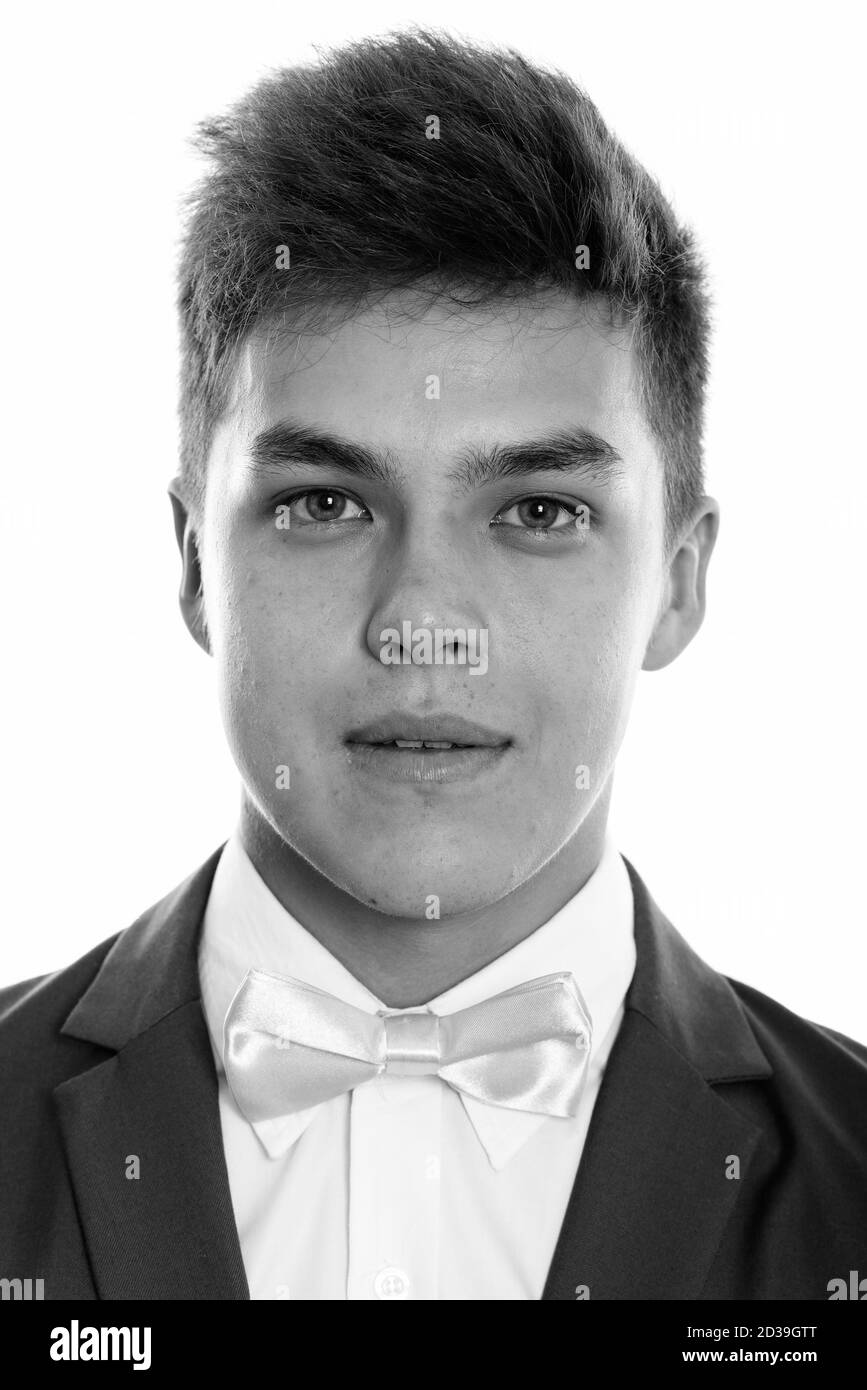Face of young handsome man wearing tuxedo with pink bow tie Stock Photo
