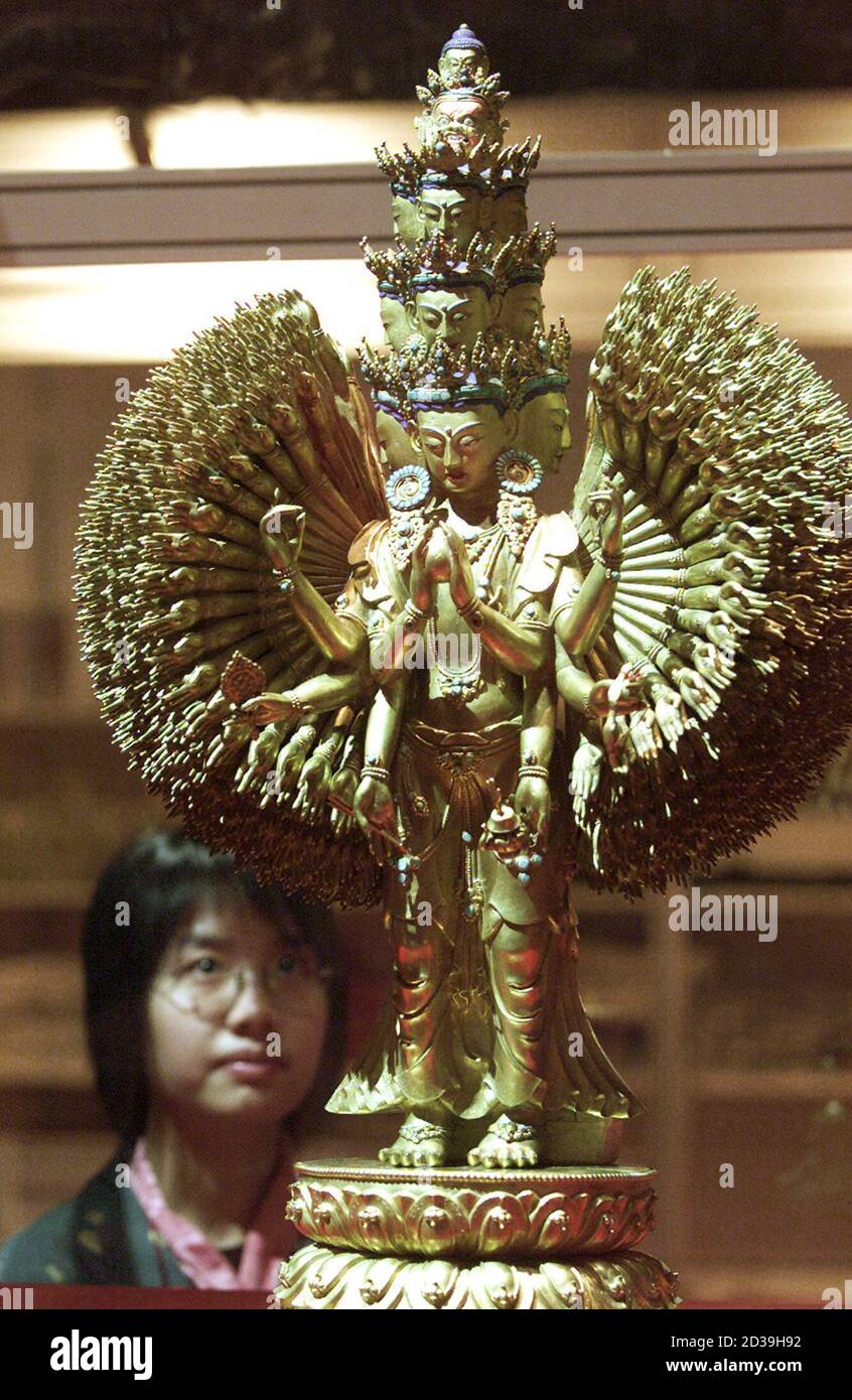 A visitor looks at the statue called "Thousand-handed and Thousand-eyed Avalokitesvara with Eleven faces", one of several Buddha statues never before been put on public display during the exhibition titled "The Treasure of Tibet" in Hong Kong December 10, 2001. Tibetan monks began performing an ancient ceremony on Monday in hope of giving Hong Kong's economy a much-needed boost. REUTERS/Kin Cheung KC/DL Stock Photo