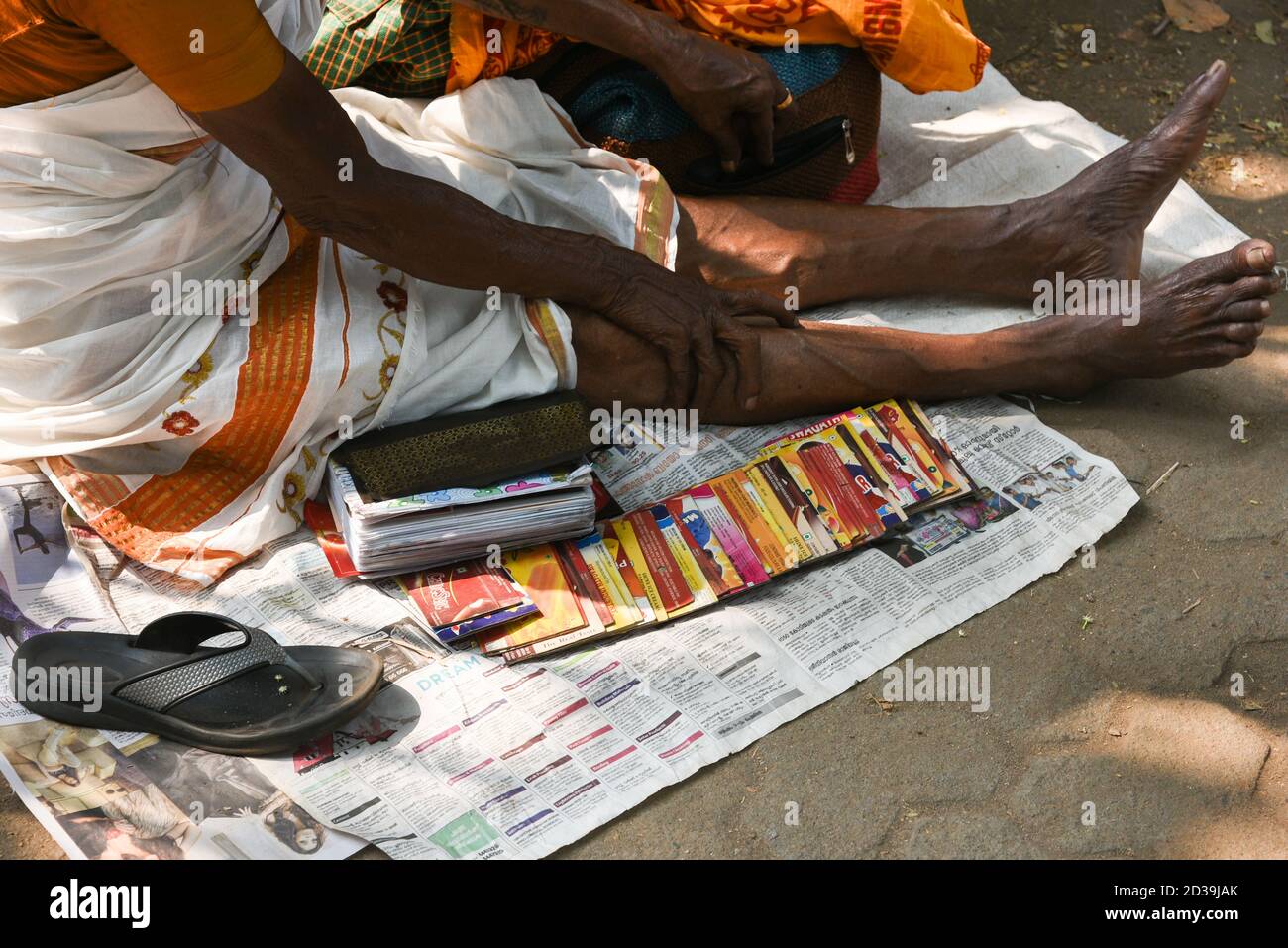 Indian woman fortune teller sitting on the ground with tarot cards spread out. Popular Hindu temple festivals of Kerala. Pooram Stock Photo