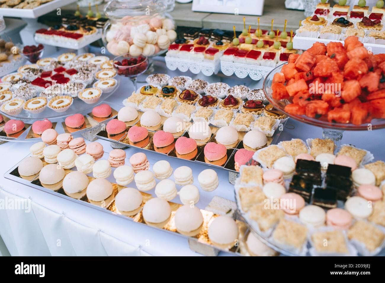 Close up of wedding candy bar with different colored bright cupcakes,  macaroons, cakes, jelly and fruits. Sweet holiday buffet with sweets and  other d Stock Photo - Alamy, image size:1300x955