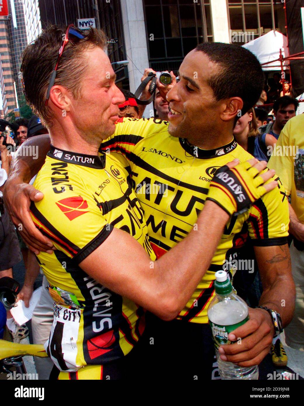 Ivan Dominguez (R) from Cuba now living in the United States, is embraced by his Saturn teammate Harm Jensen from Holland (L) after Dominguez won the first ever New York City Cycling Championship in lower Manhattan, August 4, 2002. The race was run on streets in New York's financial district. REUTERS/Mike Segar  MS Stock Photo