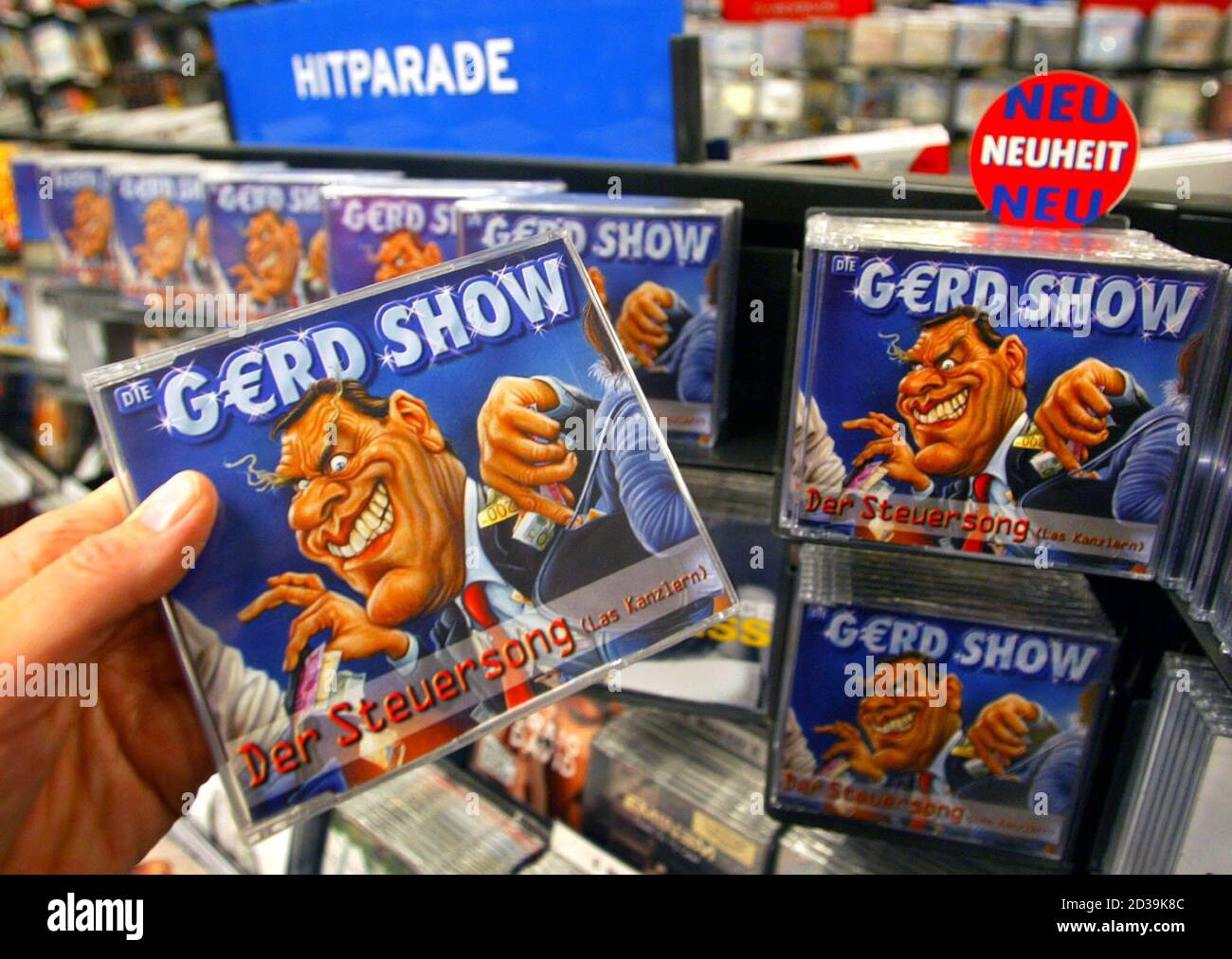 A woman holds a "Der Steuersong" CD by German mimic Elmar Brandt in a music  shop in Hamburg November 20, 2002. Schroeder has had little to smile about  lately due to public