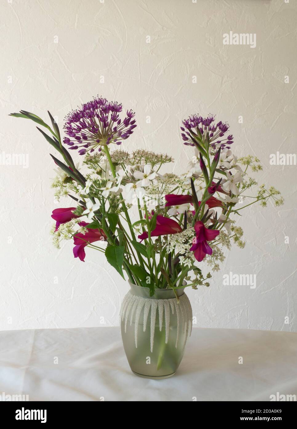Flower arrangement in patterned glass vase, including Allium, Byzantine Gladiolus and Common Bishop's Weed or Queen Anne's Lace. Stock Photo