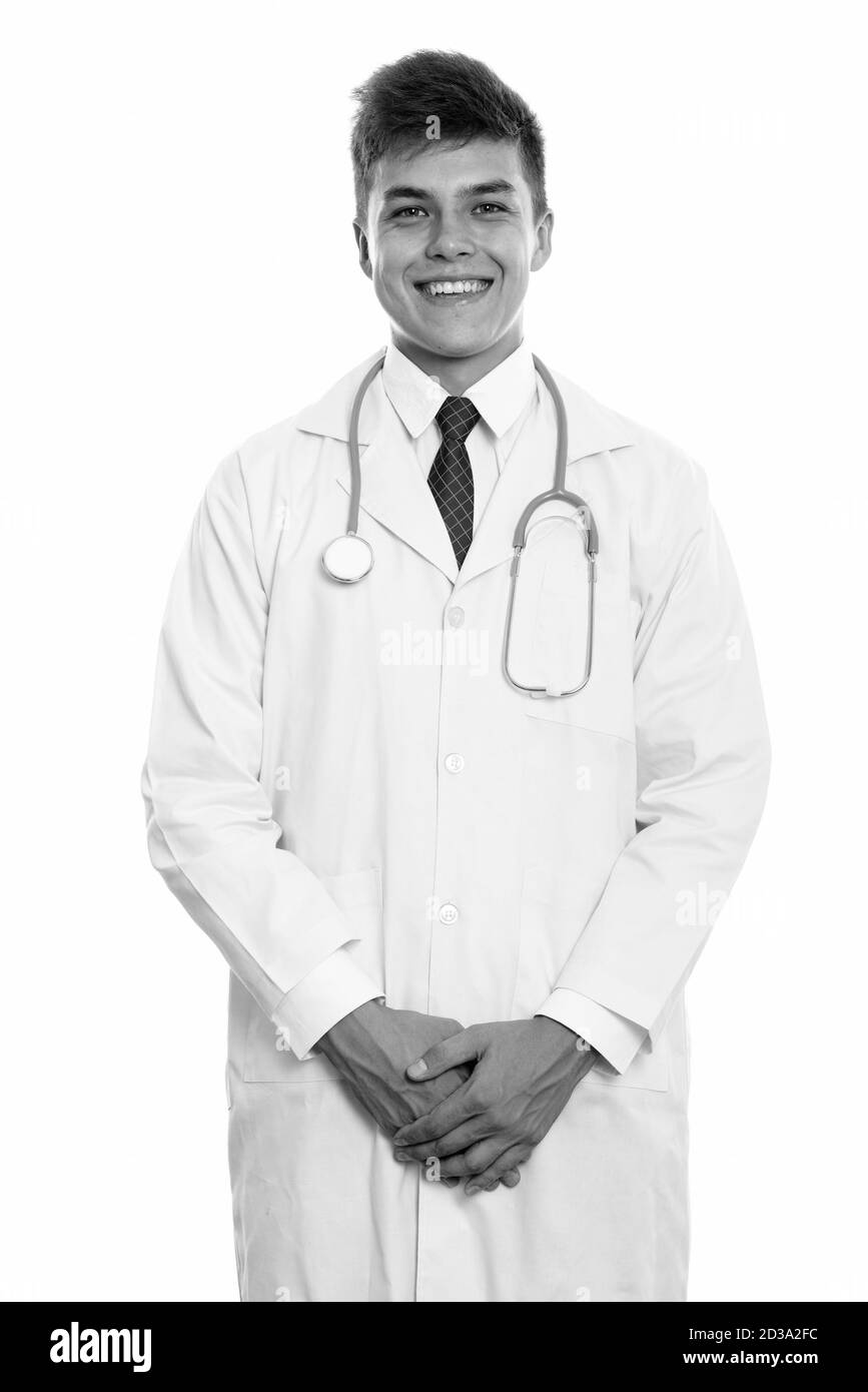 Studio shot of young happy man doctor smiling while standing Stock Photo