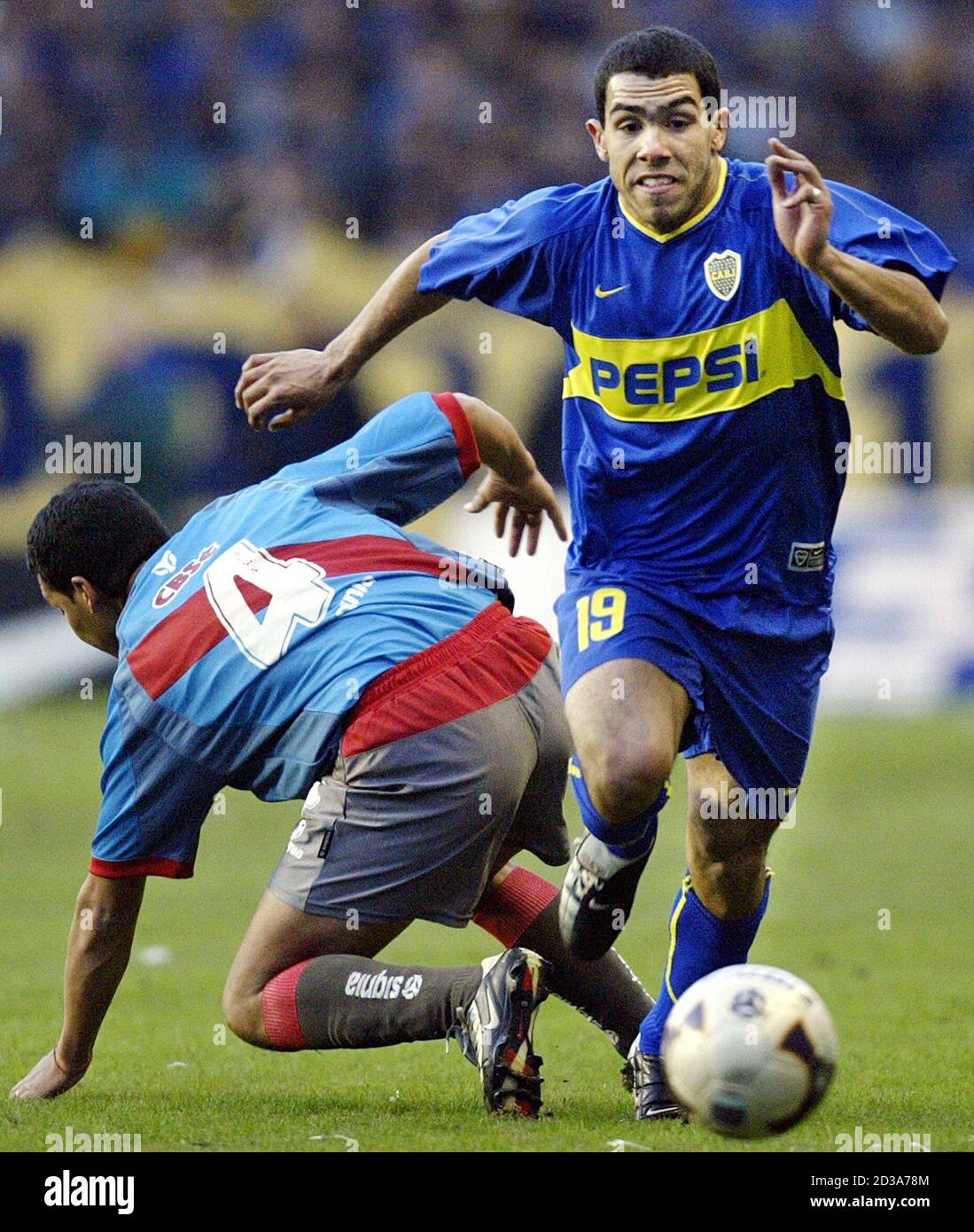 Carlos Tevez of Boca Juniors (R) moves the ball upfield past Arsenal's  Dario Espinola, during their