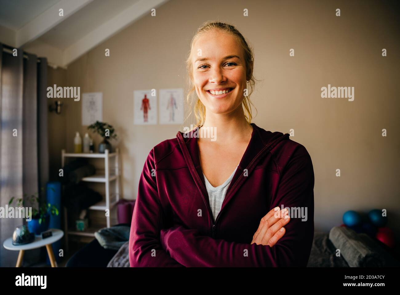 Beautiful caucasian physio female smiling crossed armed in massage room. Stock Photo