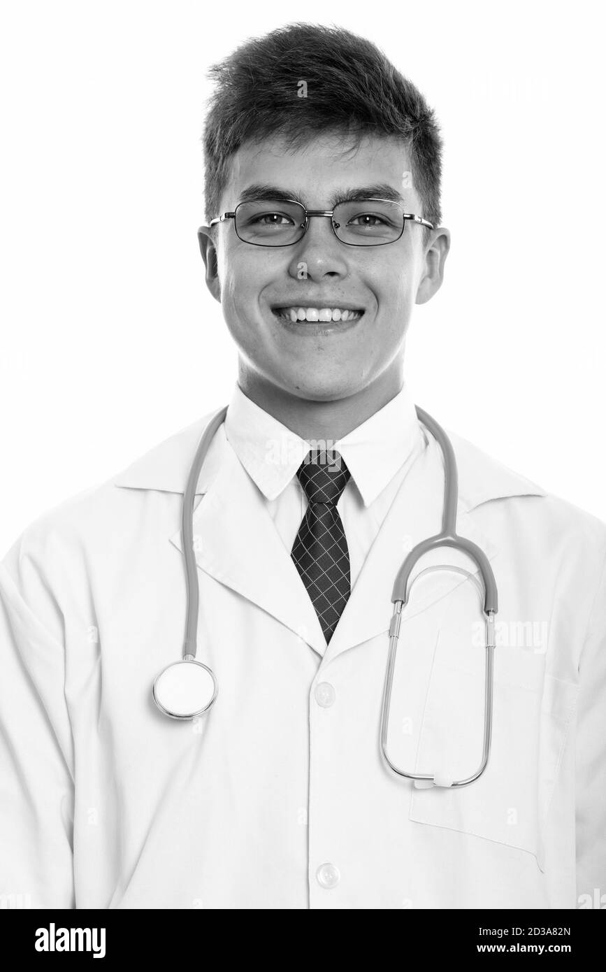 Studio shot of young happy man doctor smiling with eyeglasses Stock Photo