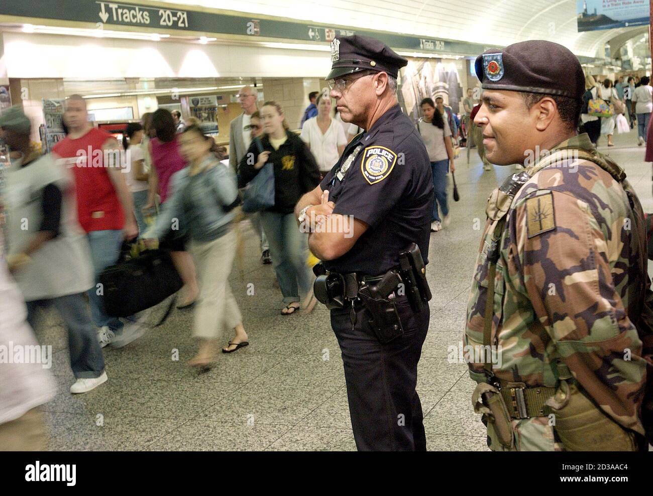 Metropolitan Transit Authority Police Officer Dennis Esterow (L) and New  York National Guardsman Spc. Daniel Garcia keep watch in Penn Station,  below the site of the upcoming Republican convention, August 1, 2004. [