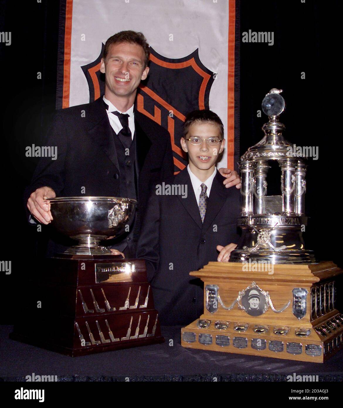 Buffalo Sabres goalie Dominik Hasek and his son Michael pose with Hasek's  National Hockey League awards during ceremonies in Toronto June 14, 2001.  Hasek won the Vezina Trophy (R) and the Jennings
