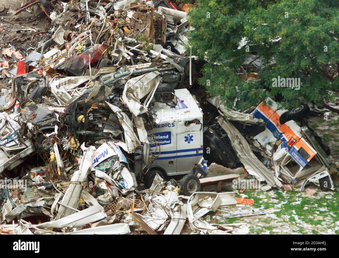 Destroyed vehicles, including ambulances, are piled up near the site of the World Trade Center attack in New York September 21, 2001. The vehicles were crushed when the Trade Center towers collapsed in the attack September 11. Rescue workers brought in more heavy equipment to clear the smoldering ruins of the World Trade Center on Friday, a tacit admission that hope for finding survivors among the 6,333 missing was all but gone. REUTERS/Dylan Martinez  RTW Stock Photo