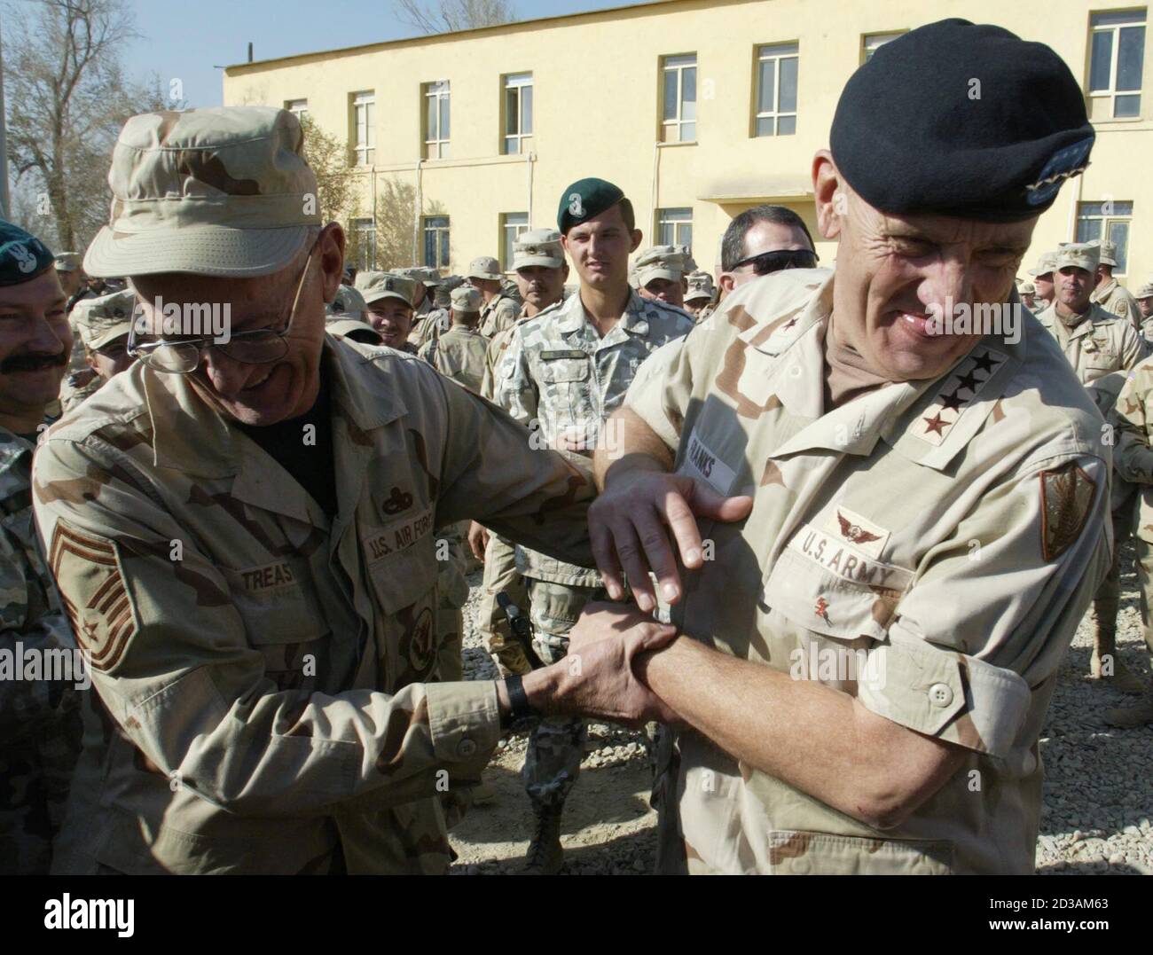 U.S. Army General Tommy Franks (R), chief of the U.S. and coalition forces, jokes with a peacekeeper from Coalition Joint Task Force 180 at Bagram air base November 29, 2002. Around 12,000 U.S. troops are participating at the operation 'Enduring Freedom' in Afghanistan. REUTERS/Radu Sigheti  RS/CP Stock Photo