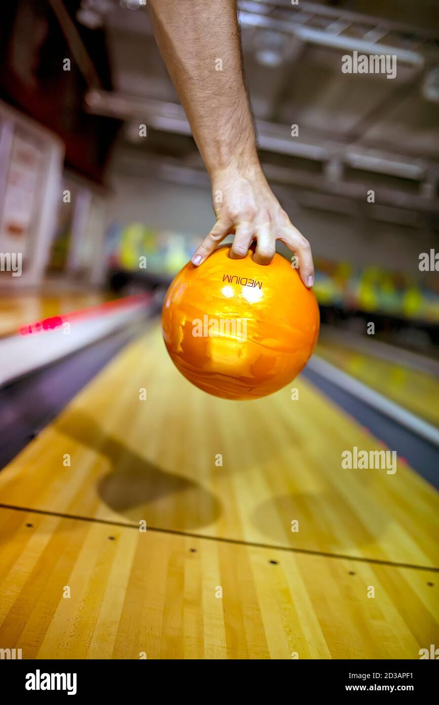 Bowling ball at hand of man background bowling alley Stock Photo Alamy