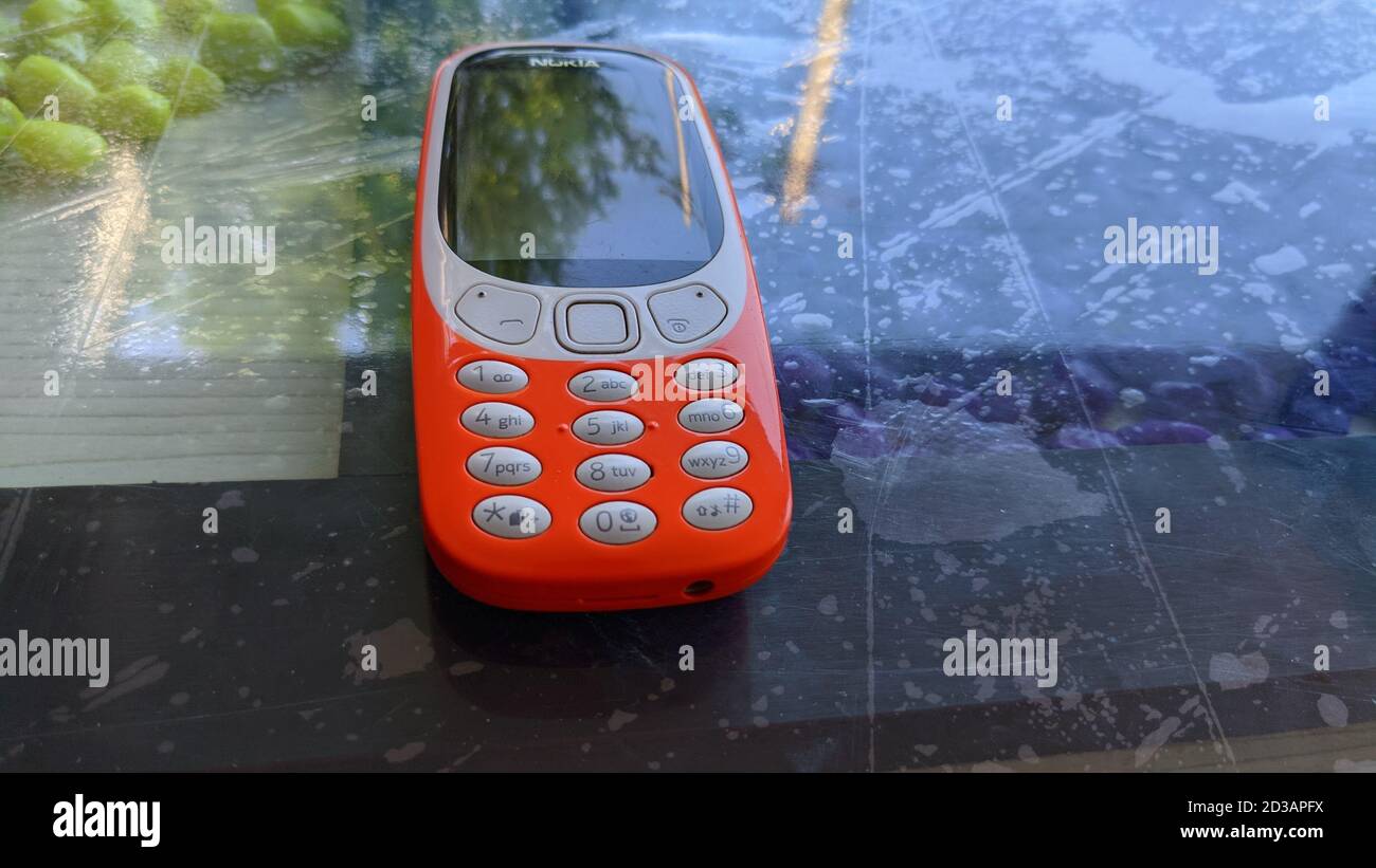 01 October 2020 : Reengus, Jaipur, India : New Nokia 3310 mobile phone on the glass table. Stock Photo