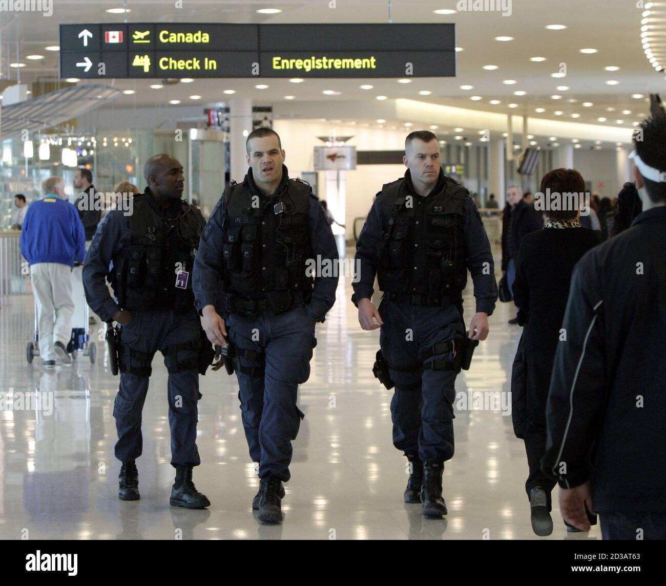 Peel Regional Police task force officers walk through the departures area of the new Pearson International Airport Terminal One, on its first day of operation, in Toronto April 6, 2004. The new terminal is part of a 4.4 billion dollar (US 494 million) expansion plan for Canada's largest airport. REUTERS/Mike Cassese  MC/HB Stock Photo