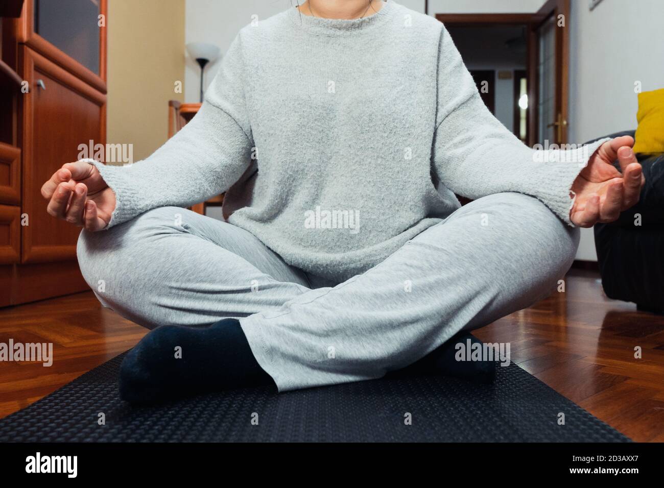 Woman meditating on the wooden floor at home Stock Photo - Alamy