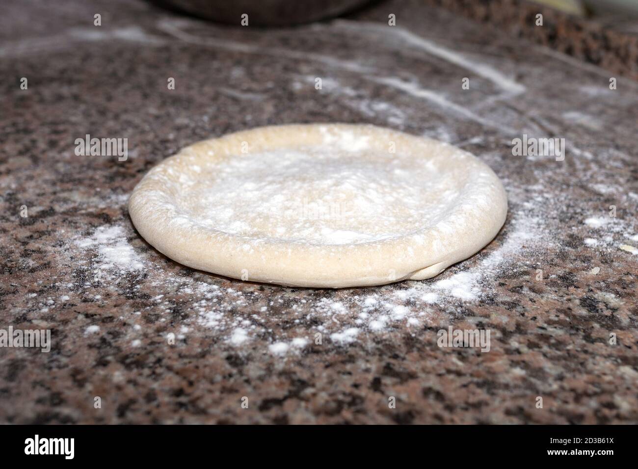 Rolled out pizza dough on floured slate surface. Horizontal image Stock Photo