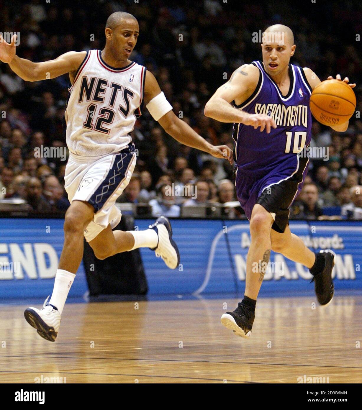 Sacramento Kings' guard Mike Bibby (R) drives to the basket in a foot race  with New Jersey Nets' guard Lucious Harris in the third quarter of their NBA  game in East Rutherford,
