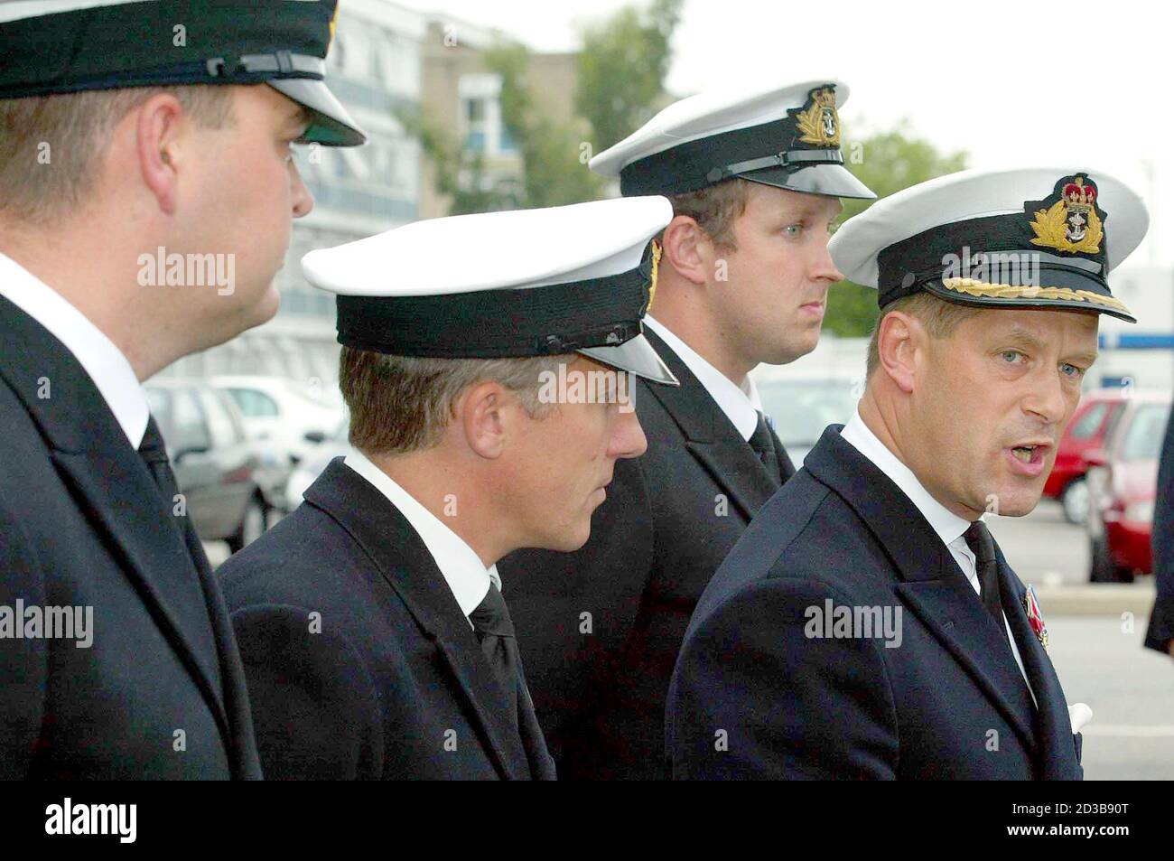 Commander Richard Farrington (R) addresses the media after a court martial hearing at Portsmouth Naval Base, flanked by L-R: Navigator Lieutenant Andrew Ingham, Lieutenant Commander John Lea, Lieutenant James Denney, September 11, 2003. Farrington was reprimanded for neglecting his duties on Thursday after his vessel HMS Nottingham ran aground near Lord Howe Island, 200 miles off the coast of Australia in July 2002, tearing a 100 ft hole down the side of the Type 42 destroyer and incurring a 42 million pounds ($66, 851, 400) repair bill. REUTERS/Lee Besford  MD Stock Photo