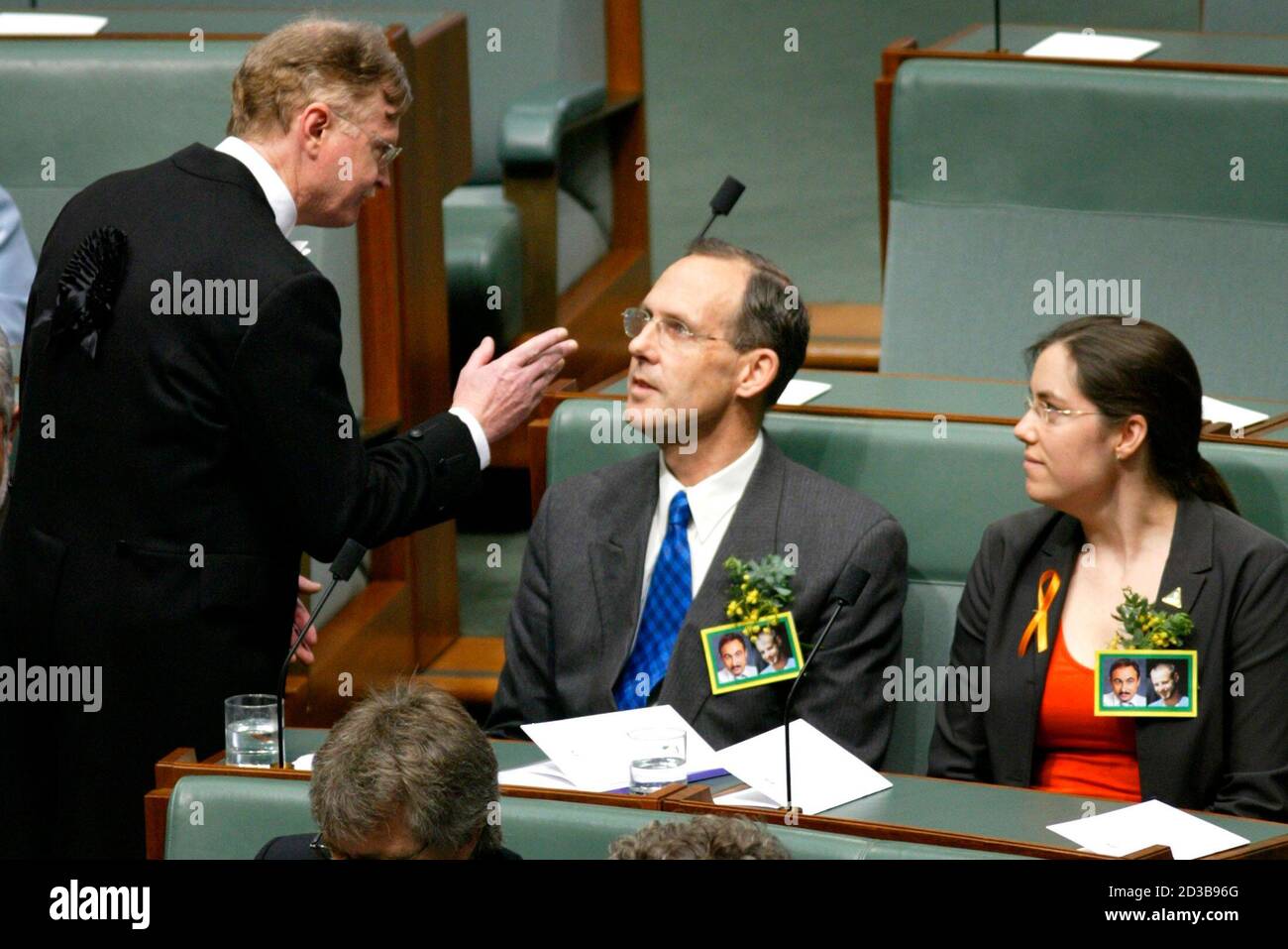 Australian Green Party senators Bob Brown (C) and Kerry Nettle (R) are  warned by an official as they interrupt a speech to Australia's Parliament  by U.S. President George W. Bush in Canberra,