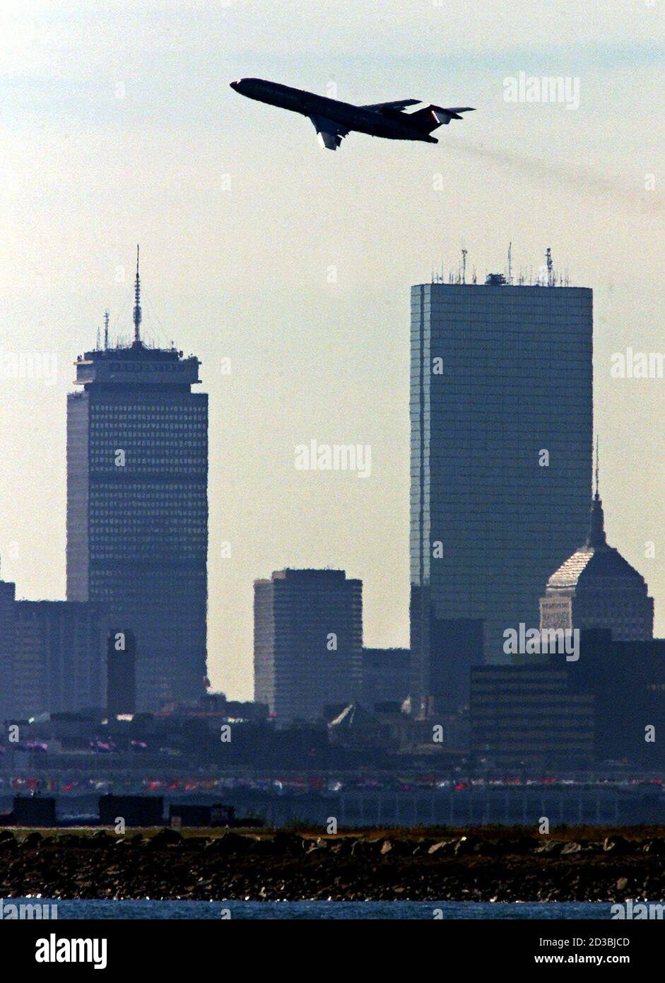 A United Airlines jetliner passes Boston's Prudential (L) and John Hancock (R) towers as it takes off from Logan International Airport October 11, 2001. Massport, the state agency which runs the airport, announced a projected $51-million budget shortfall and up to 180 layoffs exactly one month after two United and American airlines planes out of Logan were hijacked and crashed into the World Trade Center Towers. Stock Photo
