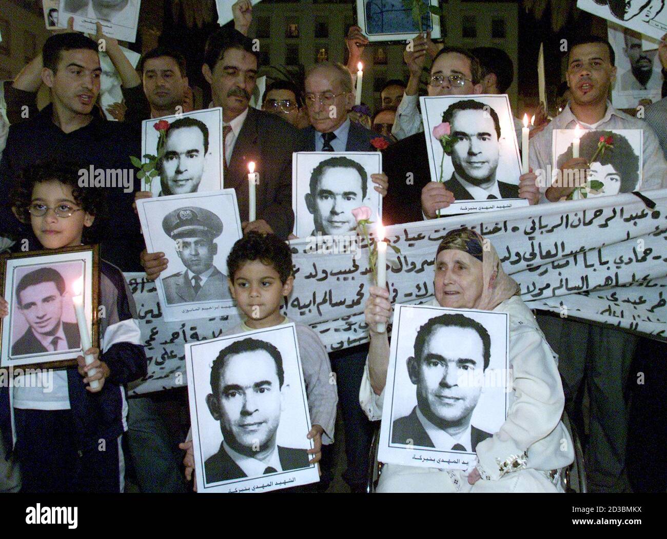 Moroccans hold portraits of former Moroccan opposition leader Mehdi Ben Barka during a candle-lit gathering in Rabat late October 29, 2002. Ben Barka, the charismatic exiled leftist leader, was seized in October 1965 in front of the Lippe cafe in the Latin Quarter of Paris, but what happened to him after remains the source of much conjecture. REUTERS/Joelle Vassort  JES/JDP Stock Photo