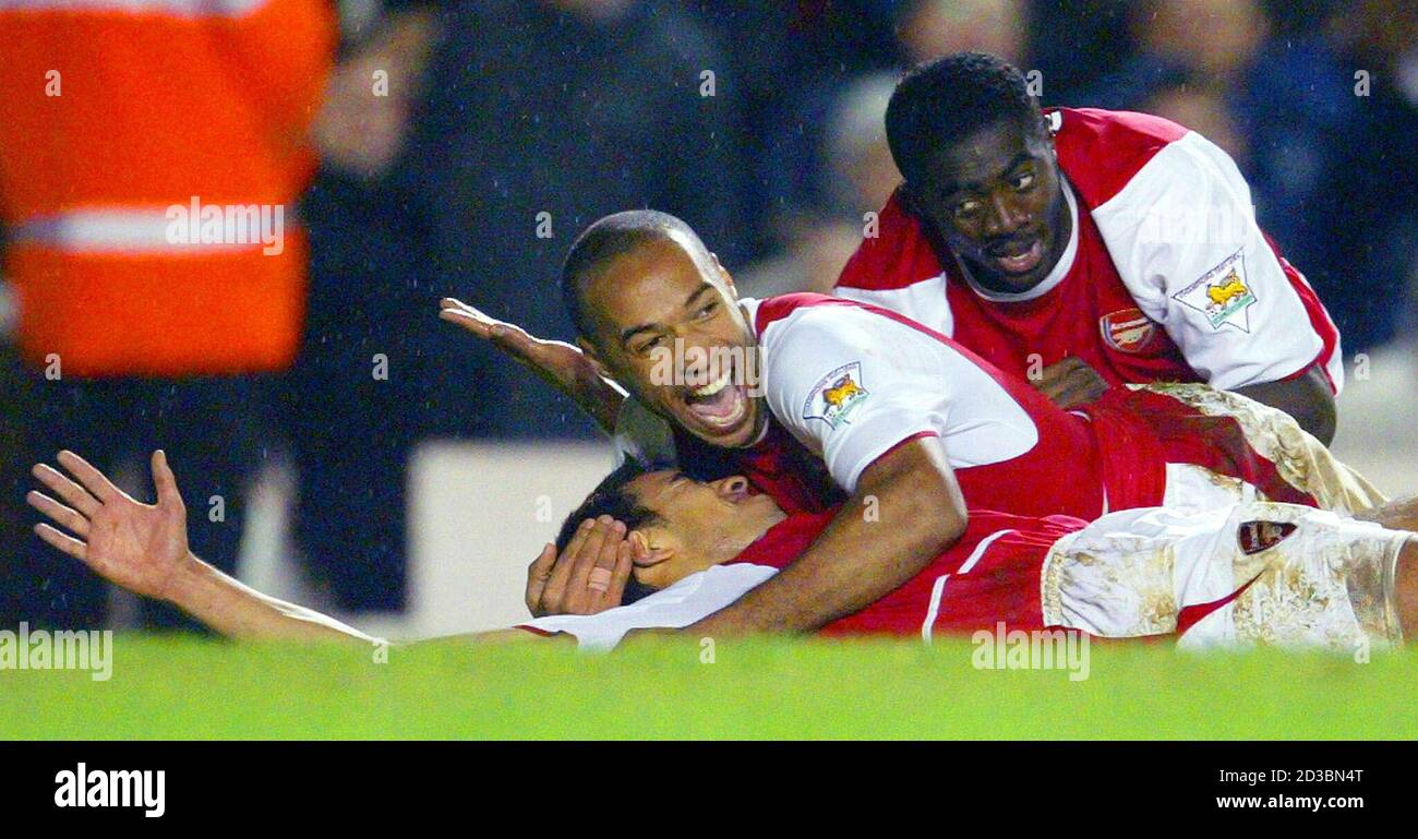 Arsenal's Gio Van Bronckhorst (L) is hugged by team mates Thierry Henry (C)  and Kolo Toure (R) after he scored against Chelsea during their English  premier league match at Highbury in London,