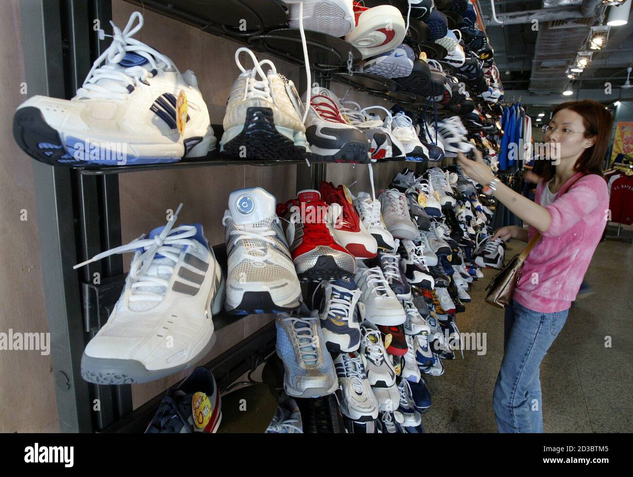 defect leef ermee grafisch A shopper picks up a China-made athletic shoe at a department store in  China's southern city of Shenzhen April 22, 2004. Southern China is home to  thousands of hangar-like factories, where millions