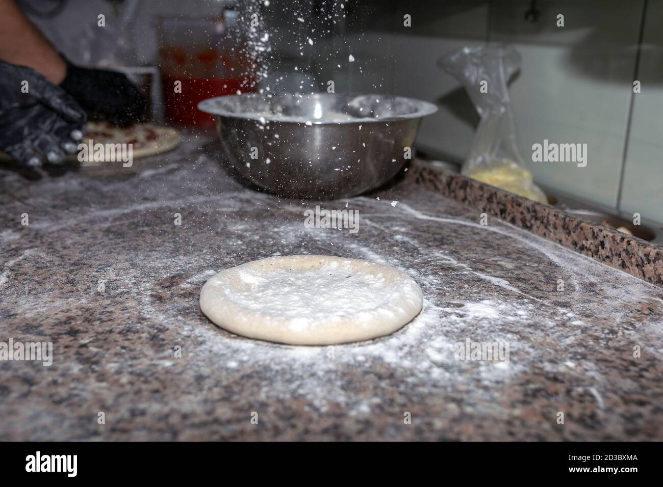 Rolled out pizza dough on floured slate surface Stock Photo