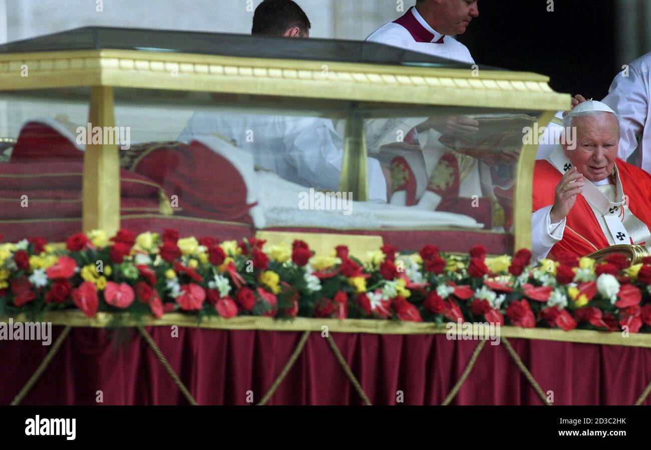 Pope John Paul II salutes the glass coffin where the body of Pope John  XXIII lies prior to a mass in Saint Peter's Square on Penticoscotal Sunday  June 3, 2001. To mark