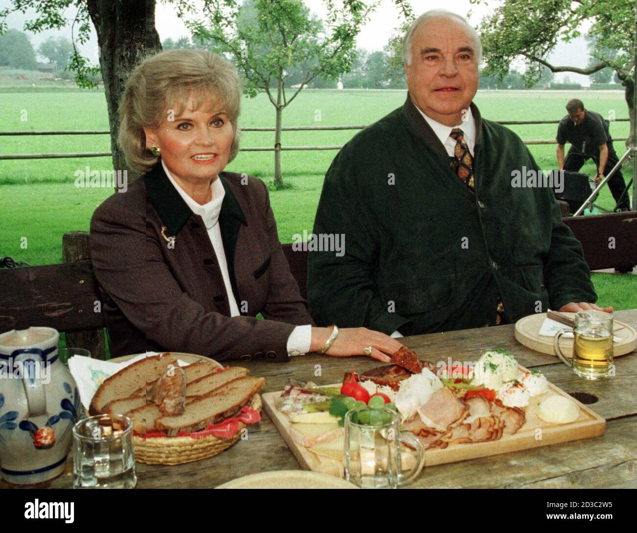 A file photo from August 4, 1998 shows German Helmut Kohl (R) and his wife enjoying traditional Austrian snack in the garden of their Austrian holiday resort in