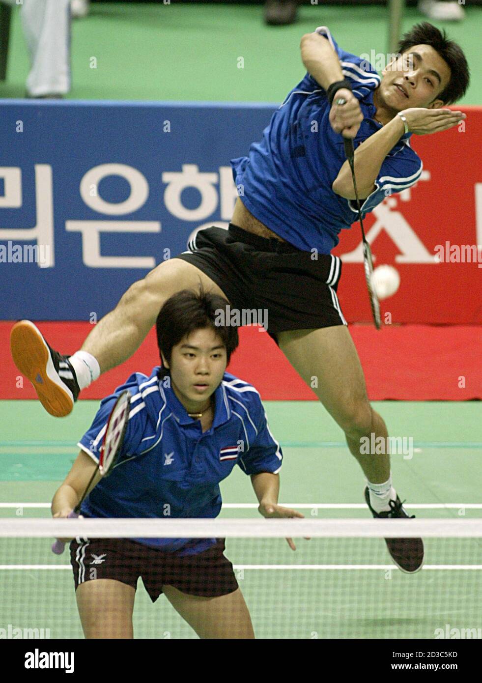 Thailand's Khunakorn Sudhisodhi jumps to smash as Saralee Thoungthongkam  waits against South Korea's Kim Dong Moon and Ra Kyung Min during the mixed  doubles badminton final at the 14th Asian Games in