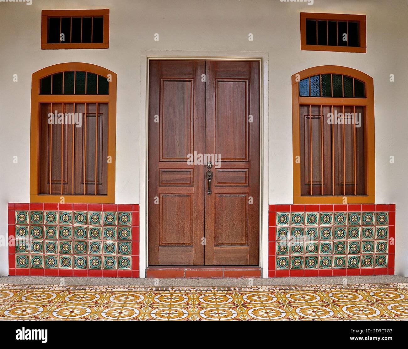 Frontage of a traditional Peranakan style Chinese shop house, with colourful geometric tile patterns on the facade. Stock Photo