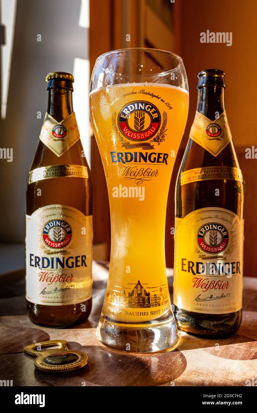 Erdinger beer is poured in a branded beer glass and two bottles Stock Photo