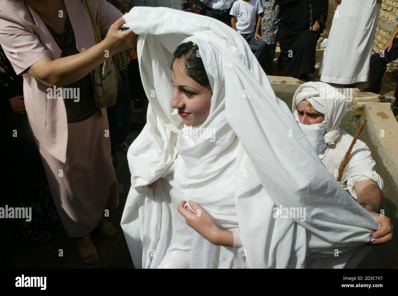 An Iraqi Mandean bride walks from a pool of water from the Tigris river after being baptised prior to her marriage in Baghdad June 8, 2003. Iraqi devotees of an obscure religion who take John the Baptist as their central figure perform virginity tests on their brides and take a dip in the murky Tigris river every Sunday to purify the soul. Most of the worldAEs 20,000 or so Mandeans live in southern Iraq and southwestern Iran. REUTERS/Faleh Kheiber REUTERS  CLH/ Stock Photo