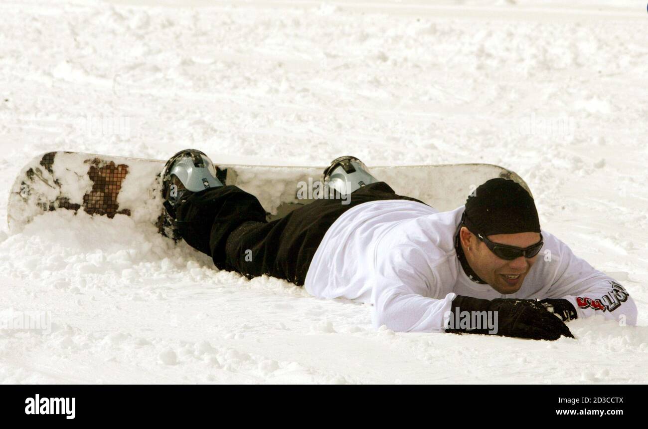 Iraq war veteran U.S. Army Sgt. Orlando Gill lies in the snow after crashing on his snowboard in Vail, Colorado February 26, 2005. Gill lost his leg below the knee when a RPG hit him but did not explode last October in Ramadi, Iraq. Gill was one of several vets invited to the Vail ski area for free private ski and snowboard lessons as part of the U.S. Department of Defense's 'America Supports You' program. REUTERS/Rick Wilking  RTW Stock Photo