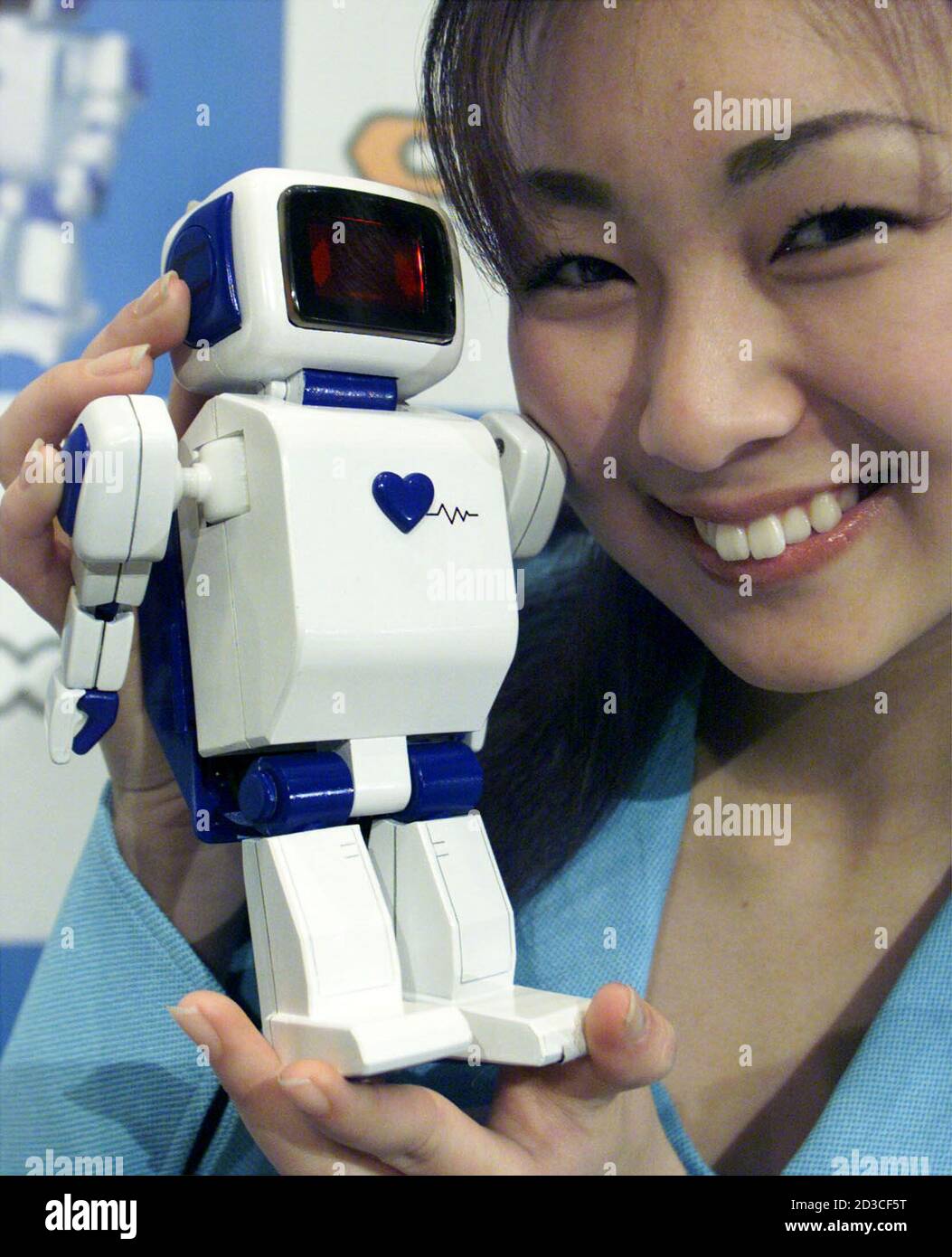 Sega Corp promotion girl Misaki Sato shows off one of five humanoid robots,  C-BOT, at an unveiling in Tokyo February 28, 2001. The C-BOT can  communicate emotions via a digital display face