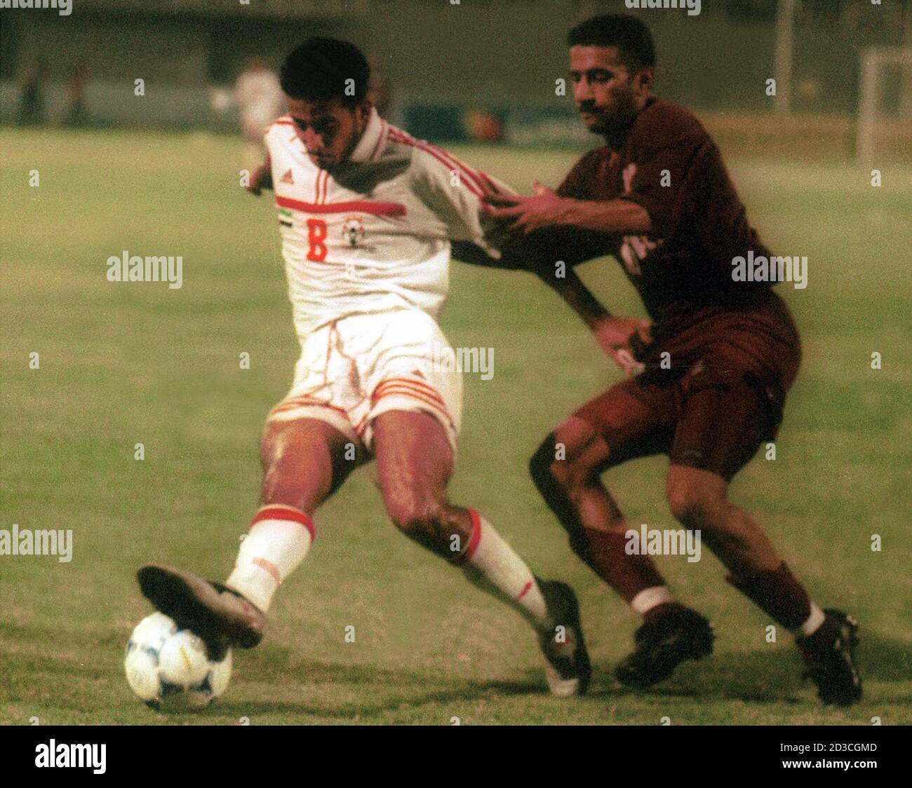 Ali Yaser Salem Saleh (L) of the United Arab Emirates tries to evade a  tackle from Qatar's Mohammed Abdul Rahman during their World Cup 2002 Asian  group B qualifying match in Abu
