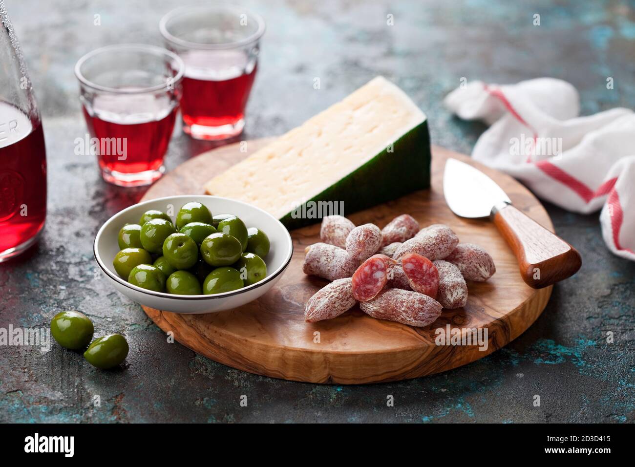 Antipasto Platter. Fuet mini sausages, green olives and cheese on wooden cutting board, selective focus Stock Photo