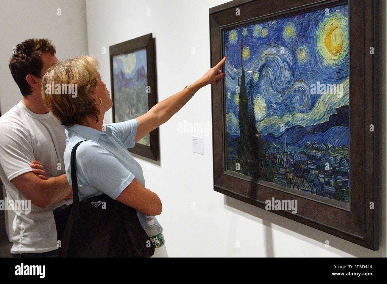Irene Hoydysh points out features of Vincent van Gogh's painting "The Stary  Night" to her son Adam, at the grand opening of the Museum of Modern Art ( MoMA) in Queens, New York,