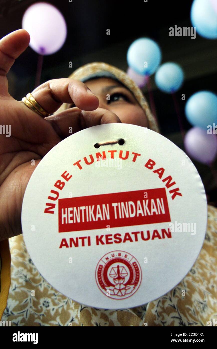 A Malaysian bank employee displays a card saying 'National Union of Bank Employees (NUBE) demands Banks To Stop Anti Union' during a protest in Kuala Lumpur December 2, 2002. Nearly 100 members of National Union of Bank Employees demonstrated against the Malaysia Commercial Banks Association, accusing the group of interfering in union related dues collections. REUTERS/Bazuki Muhammad  BM/RCS Stock Photo