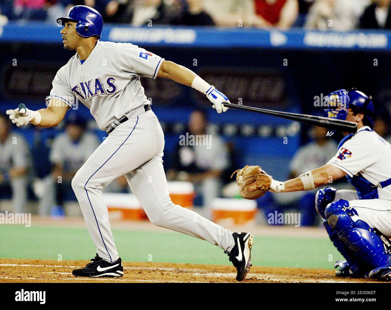 Texas Rangers Juan Gonzalez (L) follows through on a solo home run to  center field as Toronto Blue Jays catcher Greg Myers looks on during second  inning American League play in Toronto,