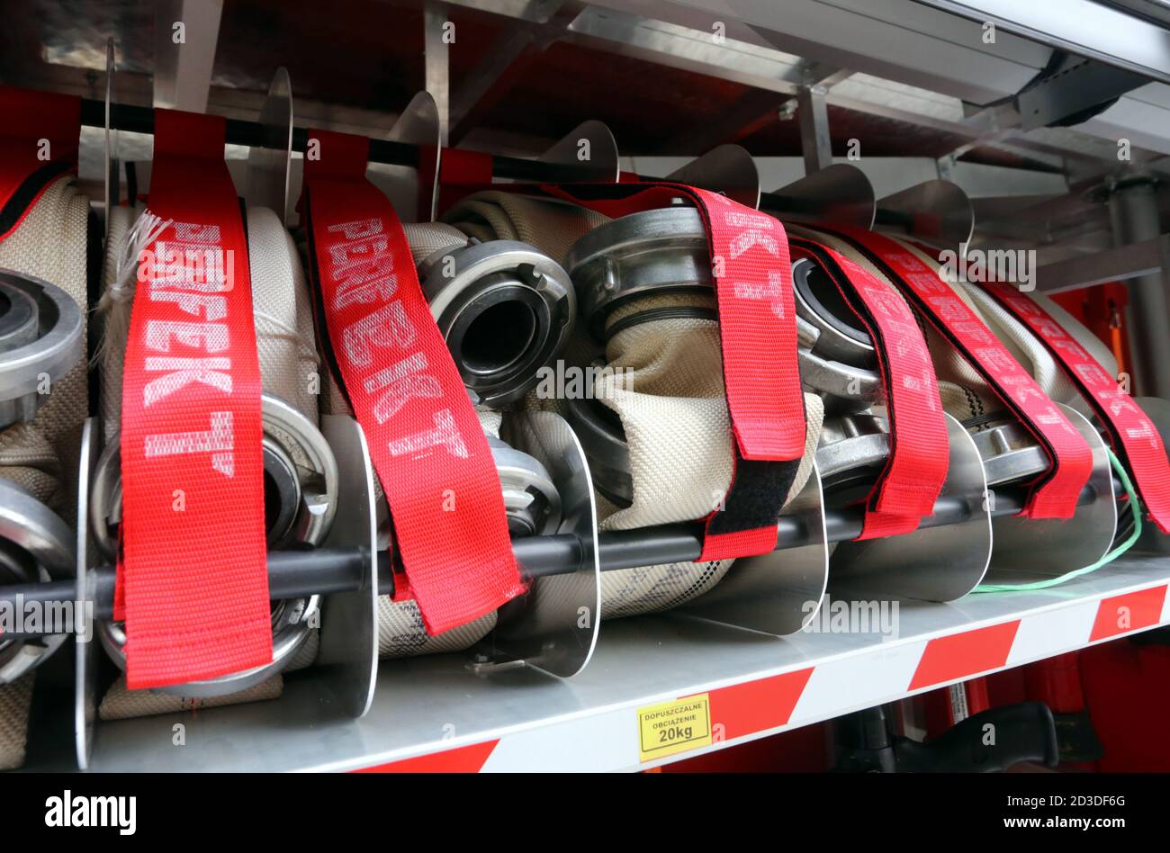 Cracow. Krakow. Poland. Canvas hosepipes with metal couplings rolled up in the fire truck storage compartment. Stock Photo