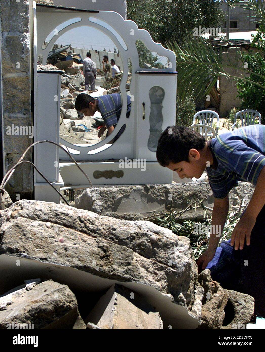 A Palestinian boy searches the rubble of his house, at Rafah border ...