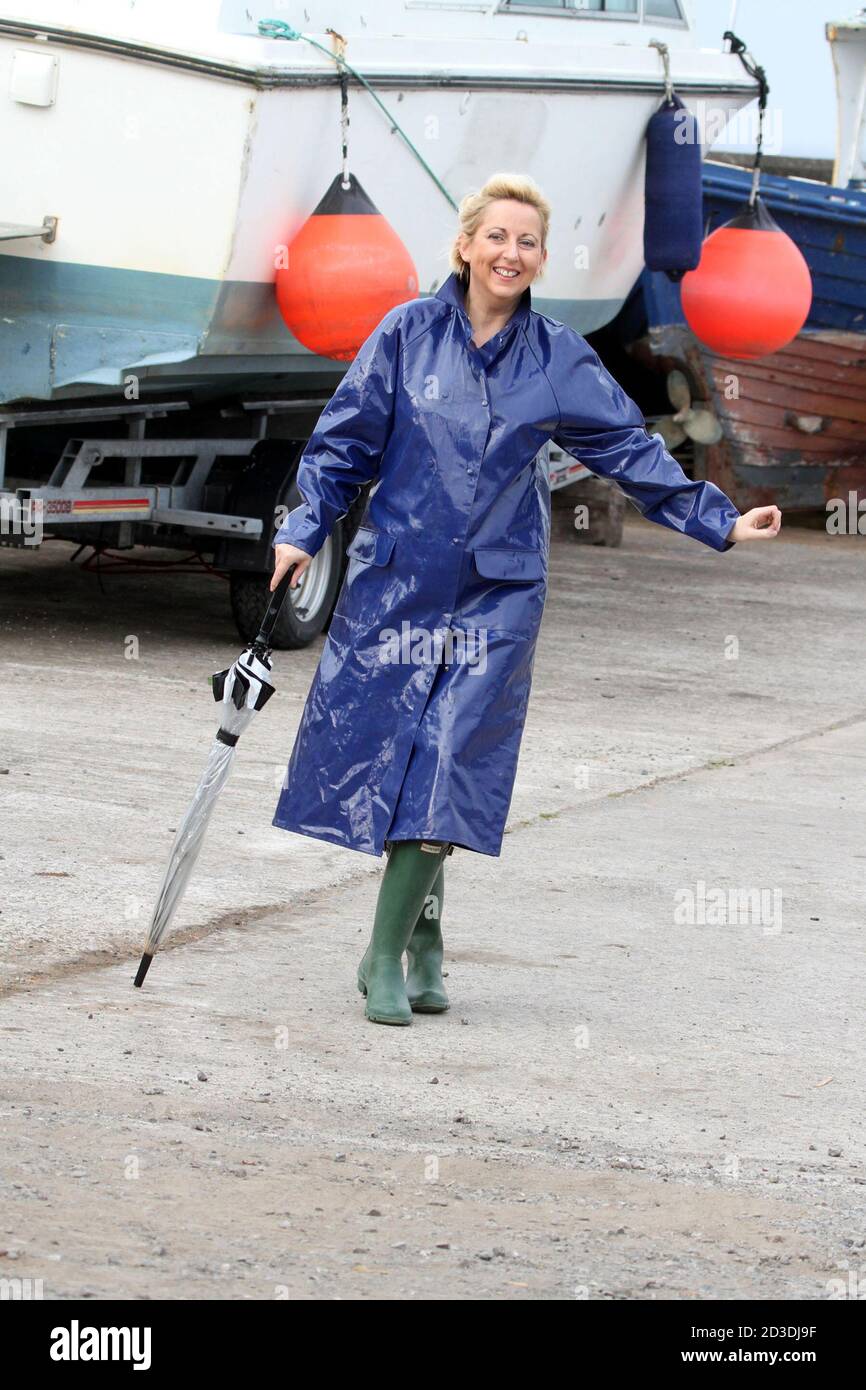 https://c8.alamy.com/comp/2D3DJ9F/white-caucasian-dyed-blonde-middle-aged-woman-in-her-40s-wearing-a-blue-shiny-pvc-raincoat-purchased-from-a-second-hand-shop-pretending-to-dance-in-her-raincoat-and-wellington-with-an-umbrella-2D3DJ9F.jpg