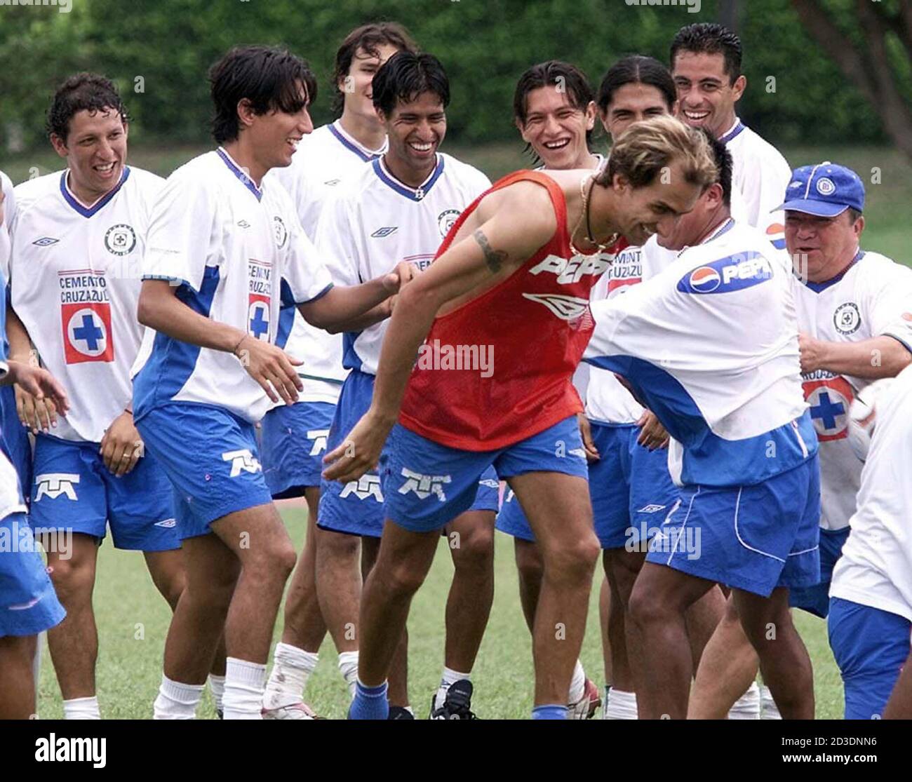 Players of Mexican soccer club Cruz Azul joke with their teammate Flavio  Davino (red jersey) during a training session in Cali, May 12, 2003. Cruz  Azul will play against club Deportivo Cali