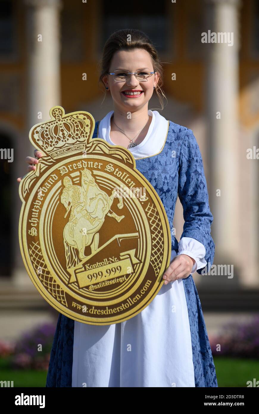 Dresden, Germany. 08th Oct, 2020. Johanna Meitzner, the 26th Dresden Stollen Girl, holds the seal of quality in her hands during her presentation in the Pillnitz Palace Park. The 21-year-old apprentice baker is the ambassador of the Dresden Christmas Stollen for the duration of one year on behalf of the Dresden Stollen Bakers. Credit: Robert Michael/dpa-Zentralbild/dpa/Alamy Live News Stock Photo