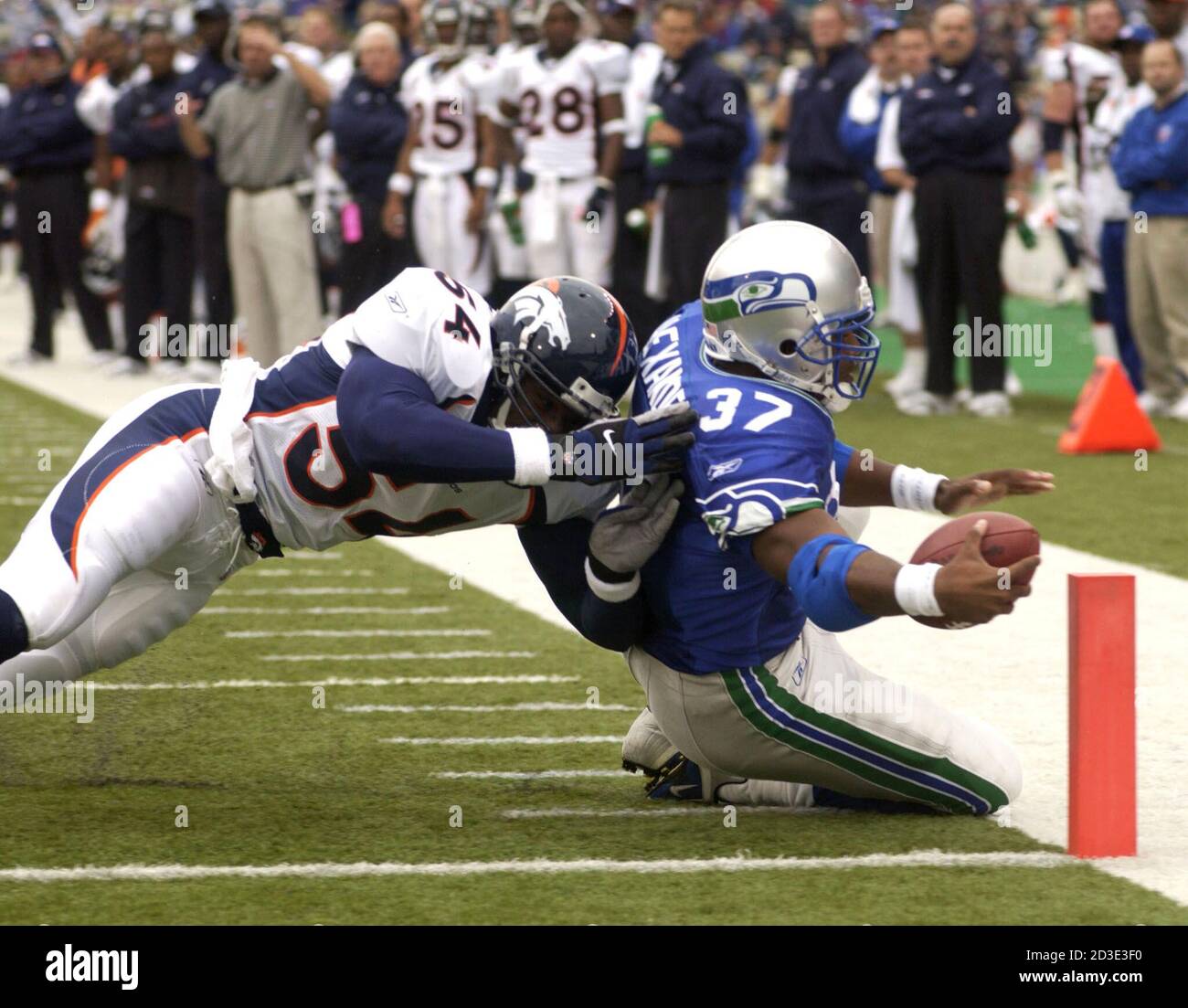 Seattle Seahawks Shaun Alexander (37) scores a touchdown before being  pushed out of bounds by Denver Broncos Lee Woodall (54) during the second  quarter of their game, October 14, 2001, at Husky